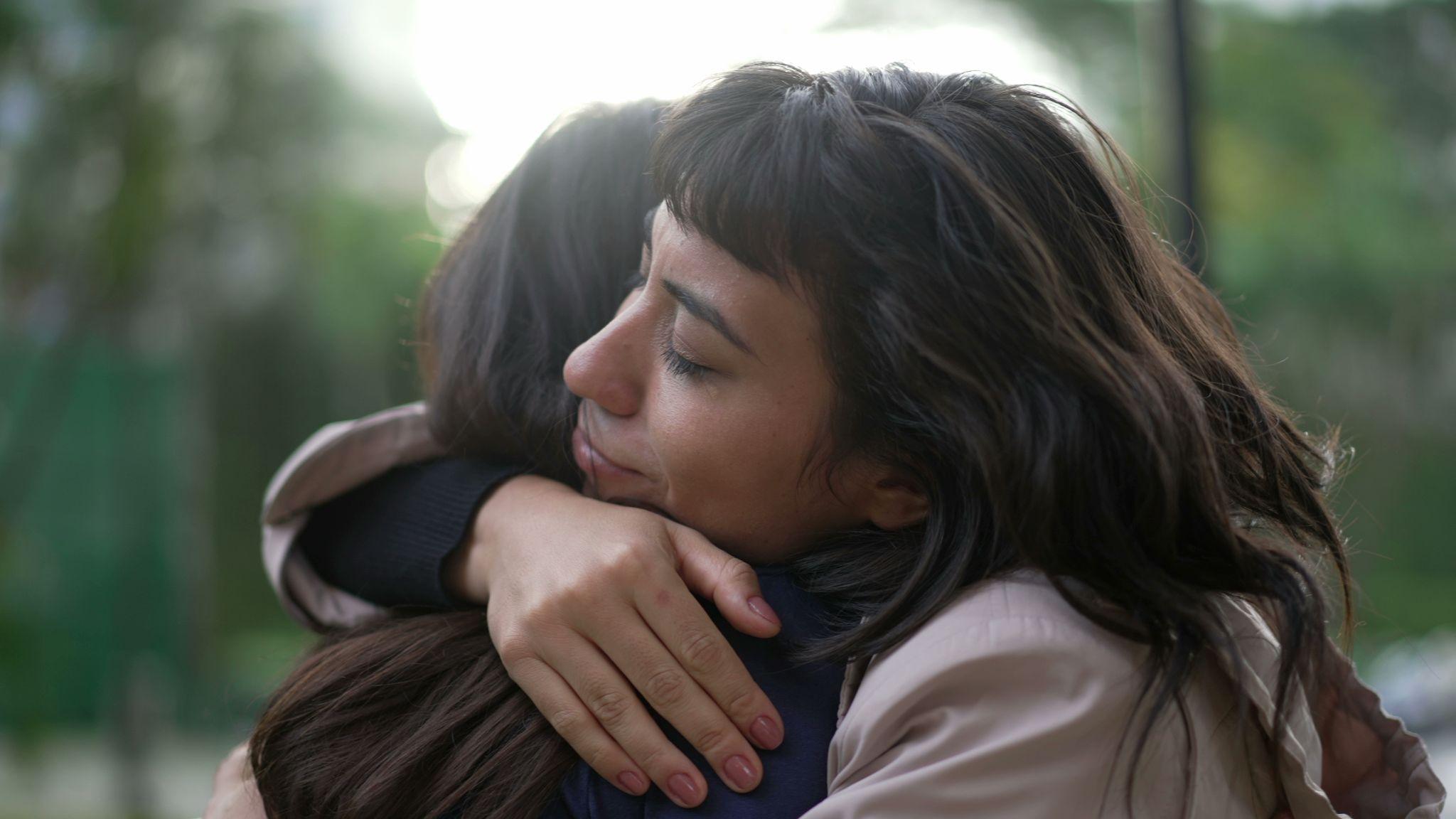 sympathetic woman hugging friend with empathy and support.