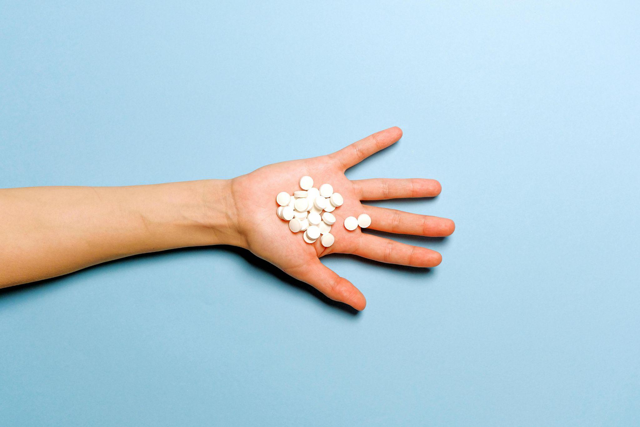 Hand with white pills
