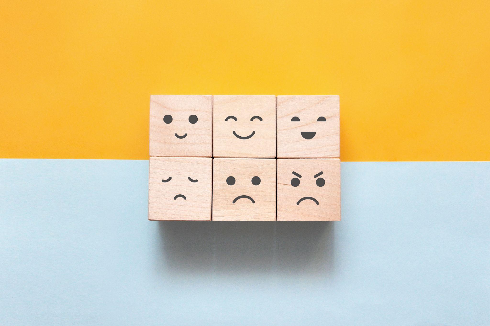 Image of different emotions on wooden cubes.