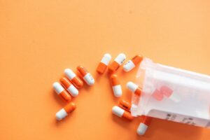 Top view of colored pills coming out of a bottle