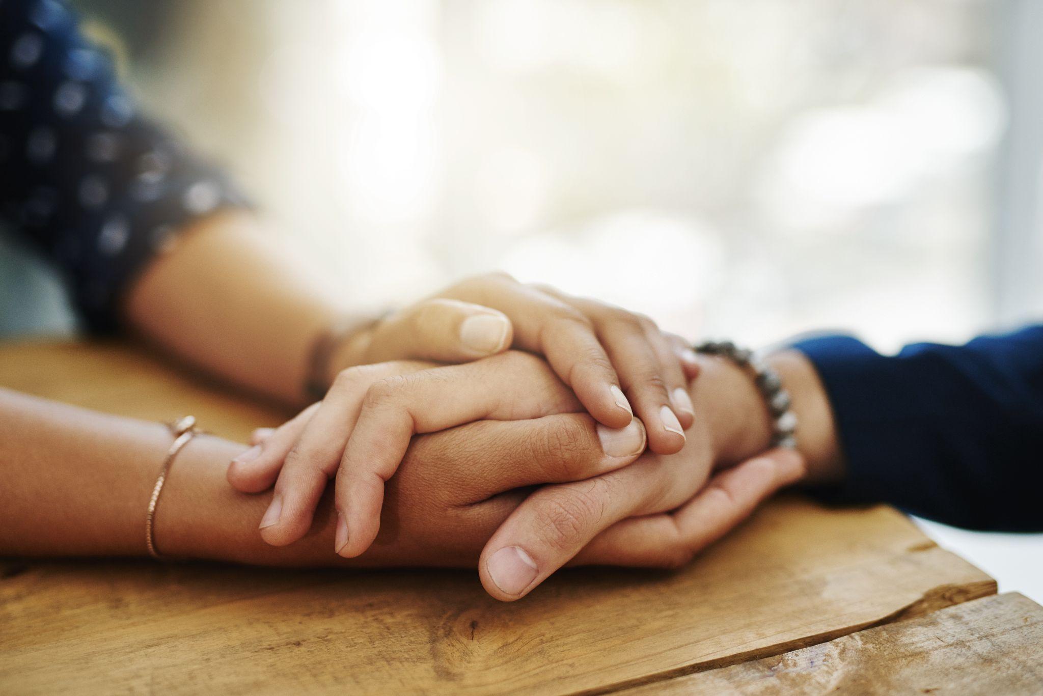 two people holding hands in comfort.