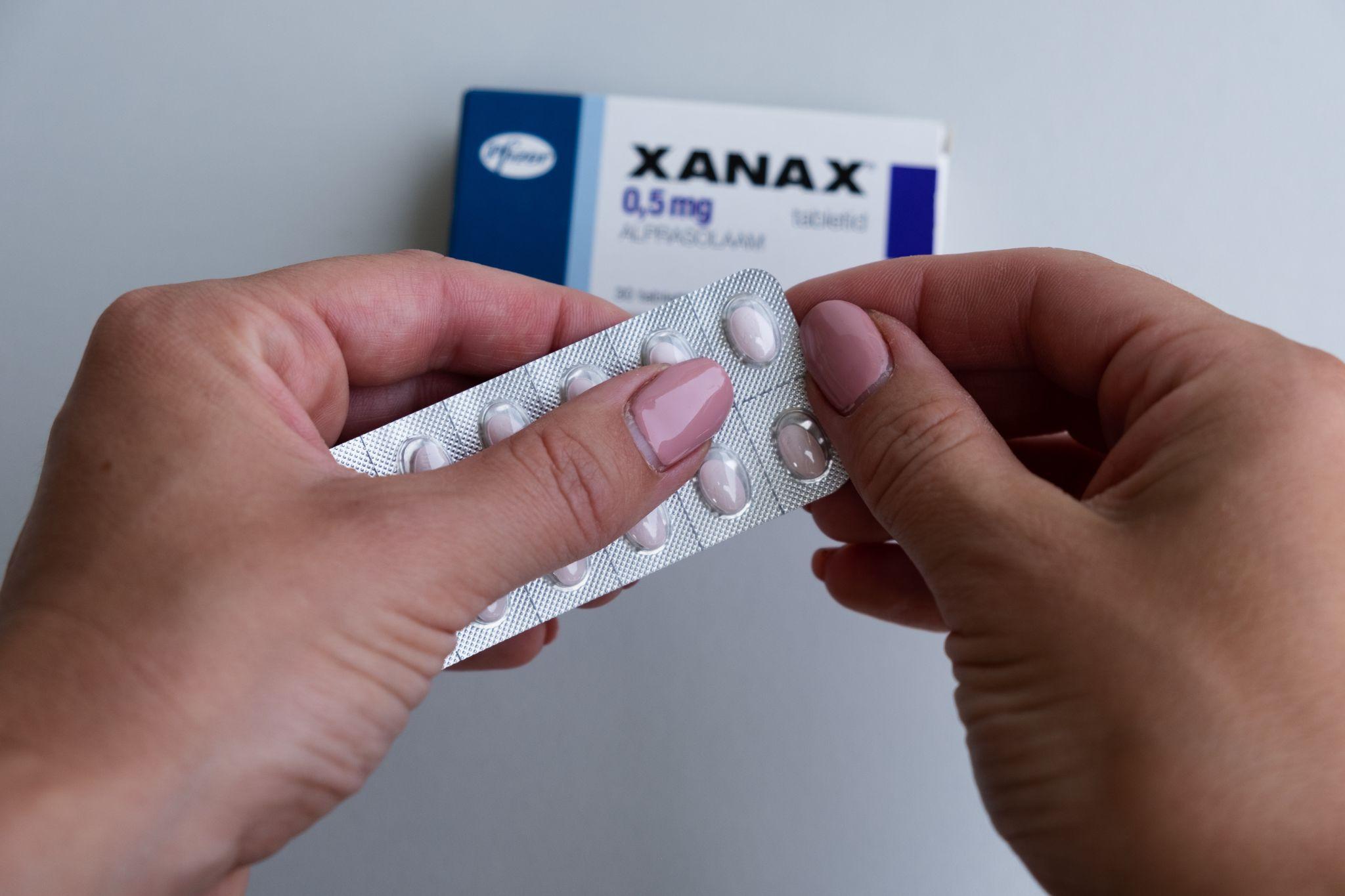 Woman taking Xanax tablet
