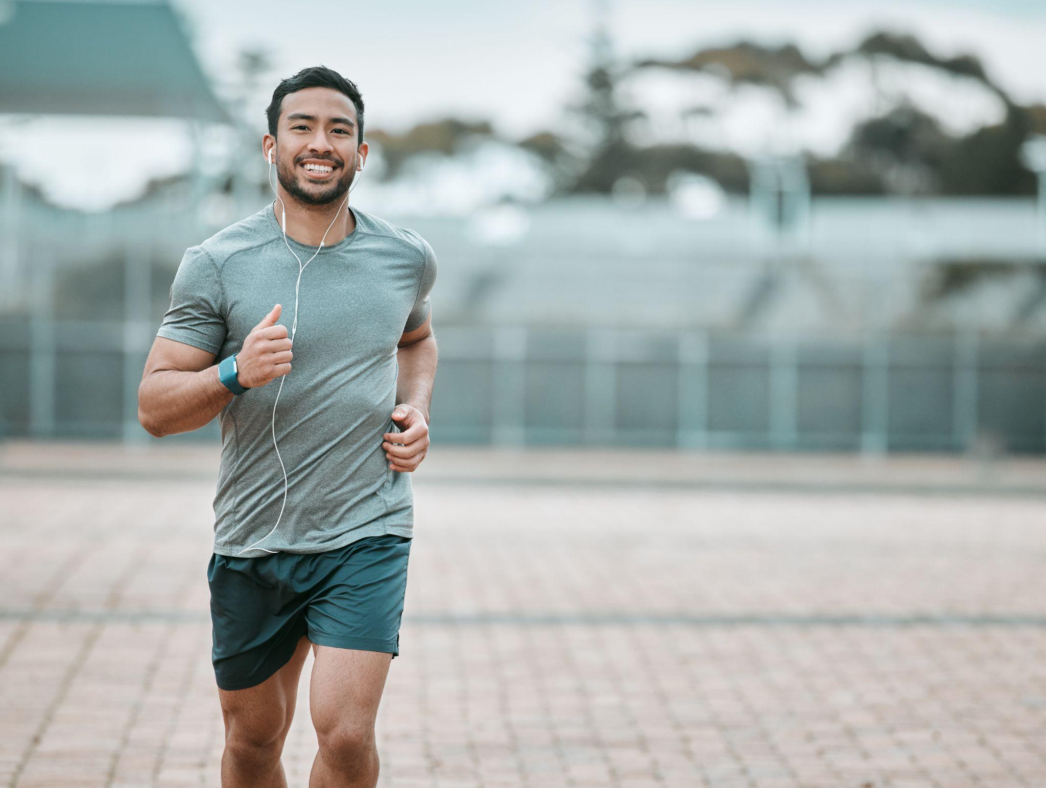 Sports, portrait and male athlete running with earphones for music