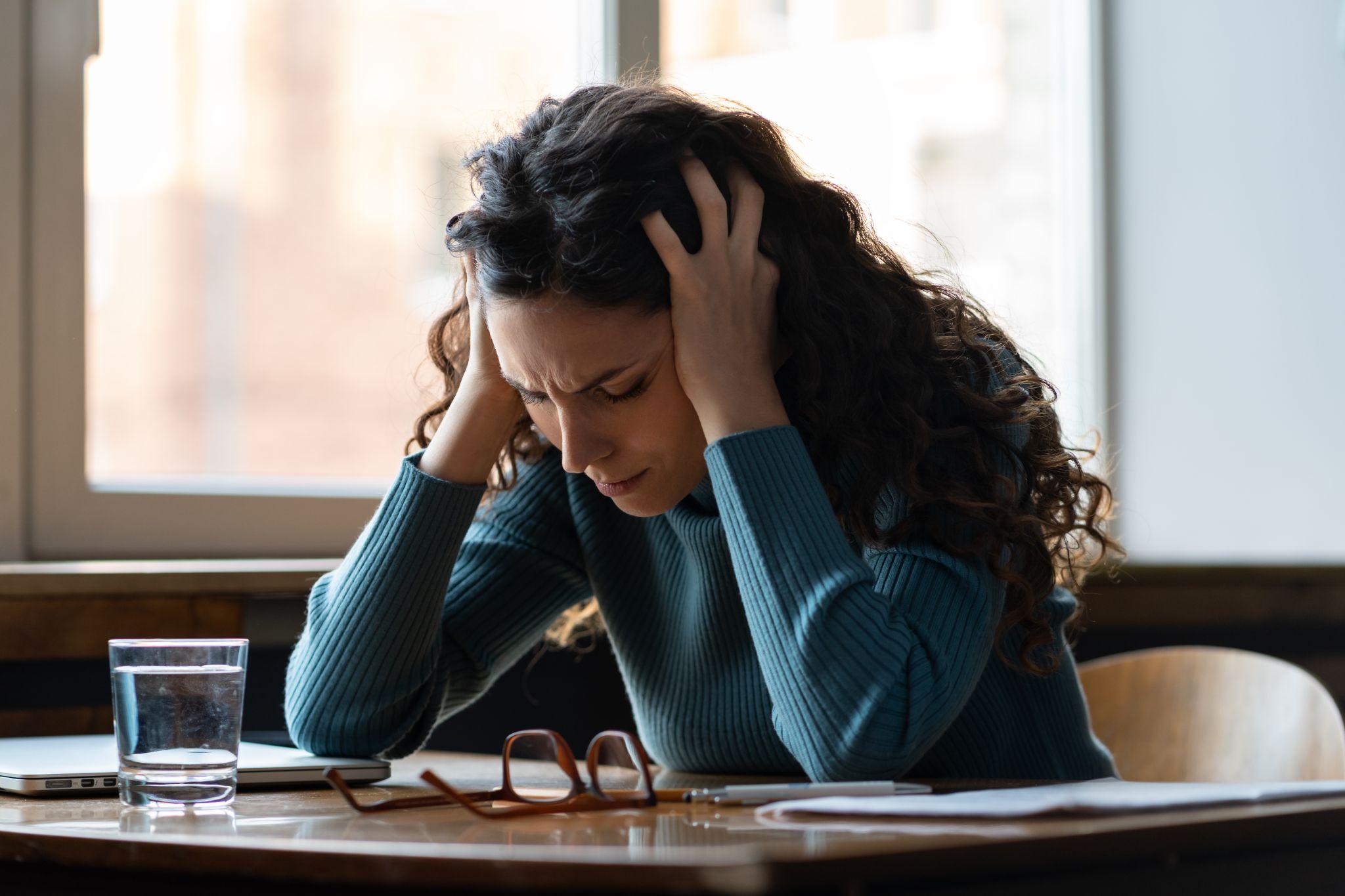 Unhappy female overworked and stressed sit at desk