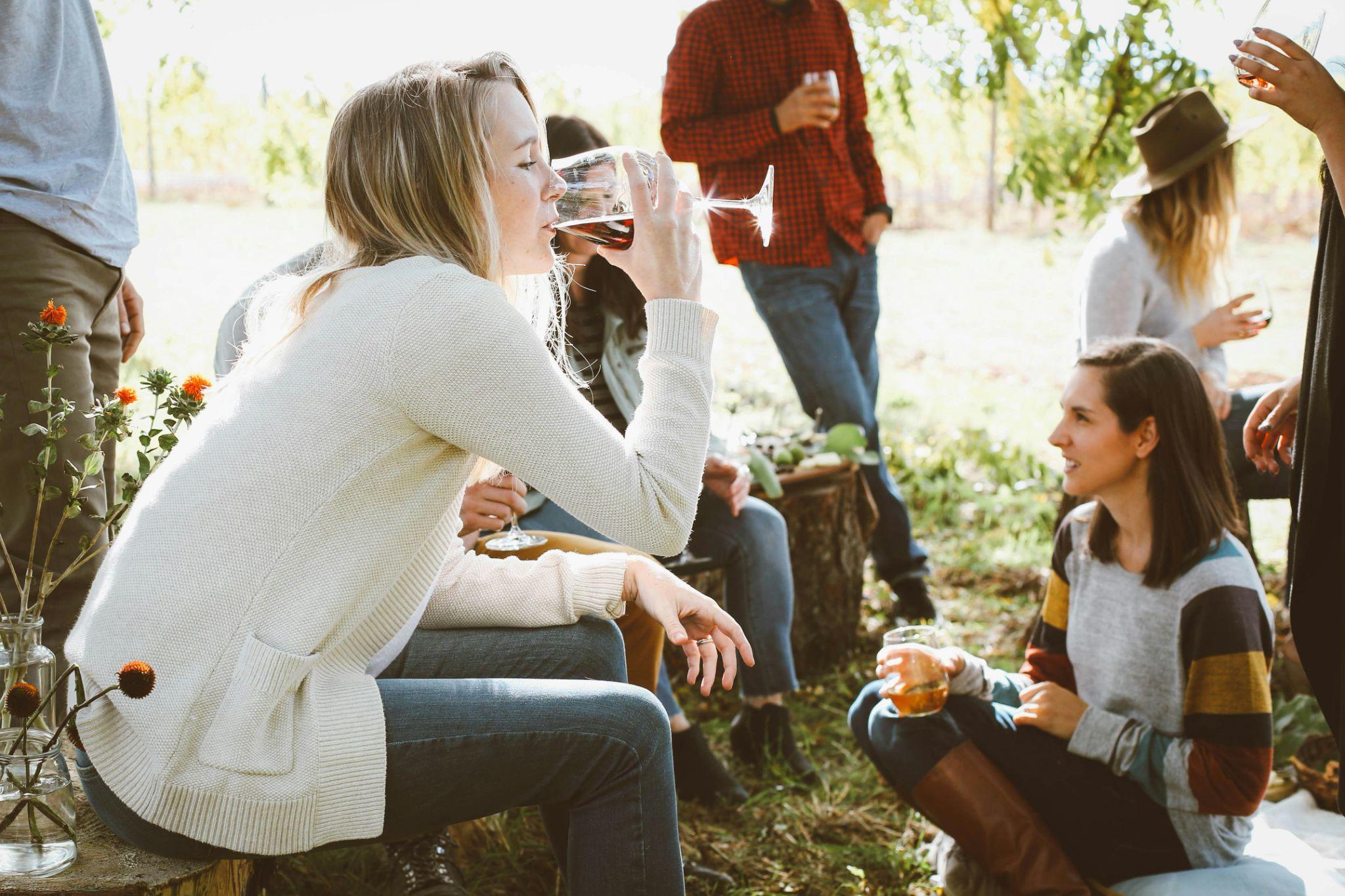 A group of women drinking outside in a group.