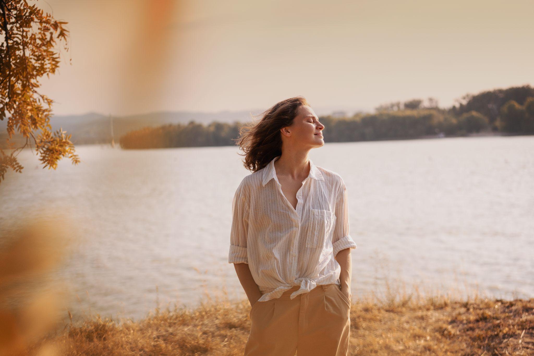 Beautiful young relaxed woman in white blouse enjoying nature