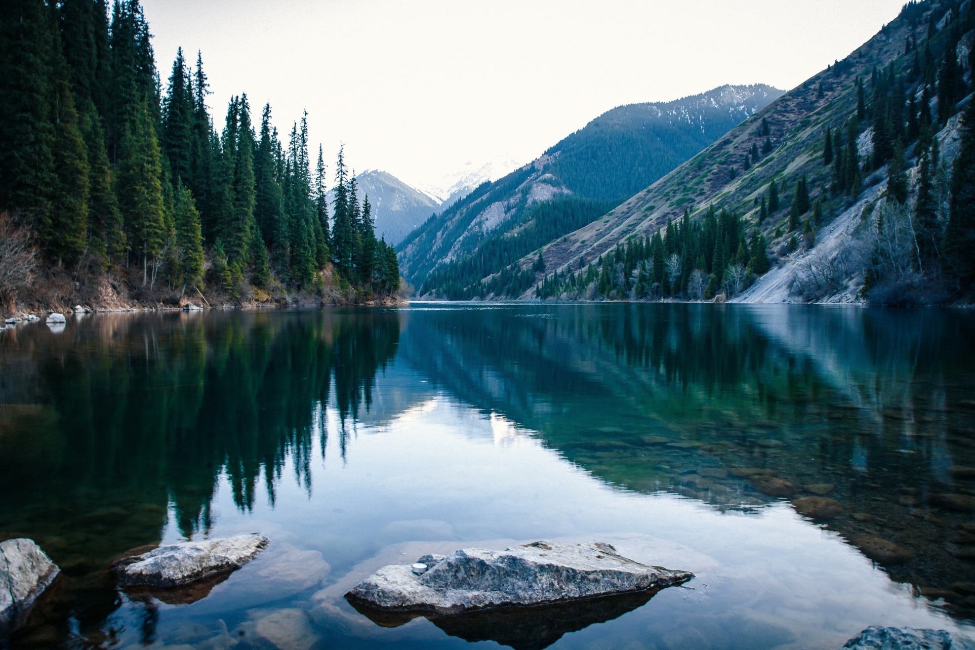 serene lake bordered by lush trees and majestic mountains