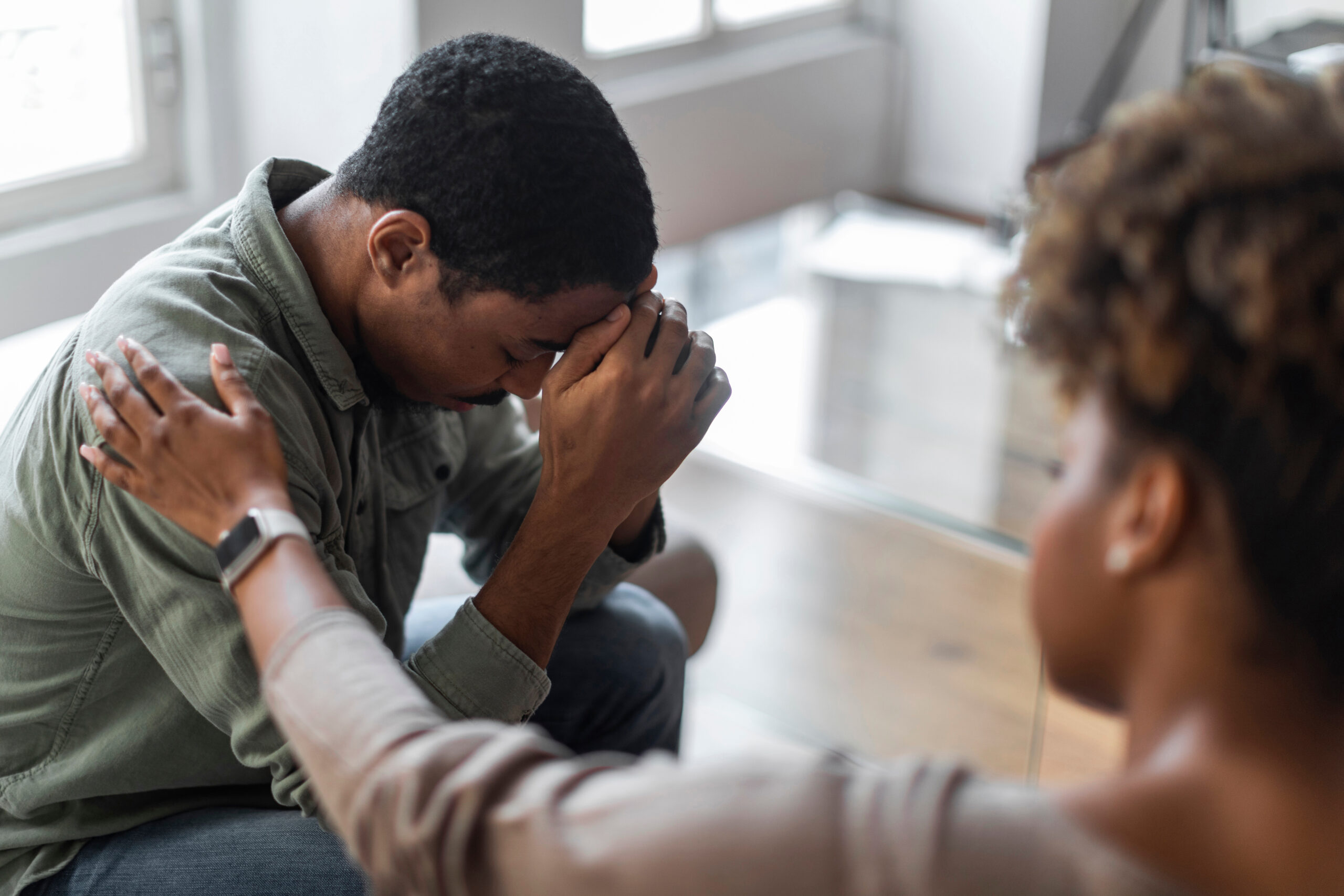 Closeup of african american psychologist helping depressed young man