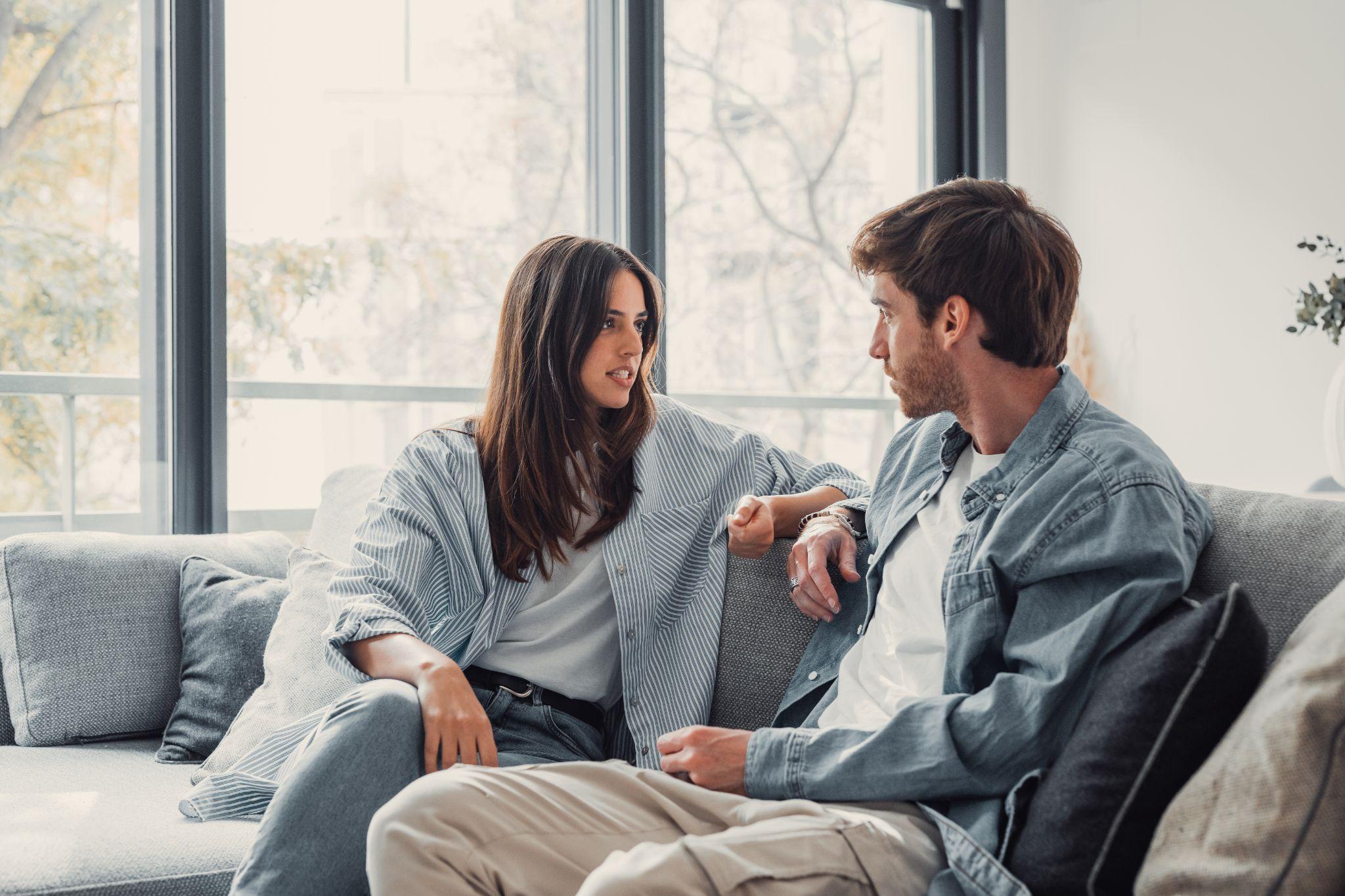 Young happy couple having fun talking laughing relaxing at home