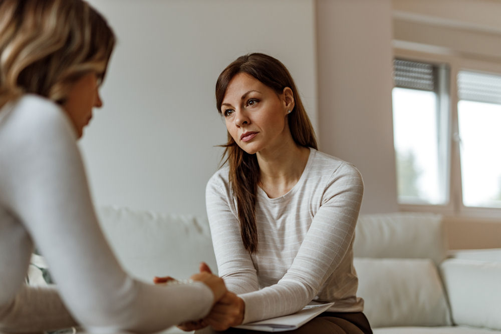 Female veteran holding the hands of a therapist during individual therapy