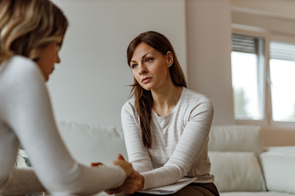 Female veteran holding the hands of a therapist during individual therapy